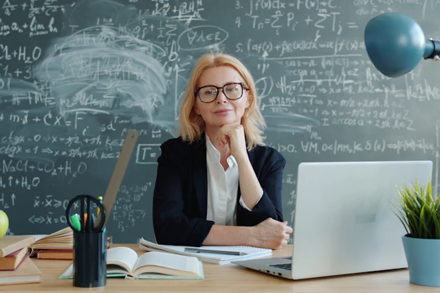 Teacher smiling at her desk in a classroom